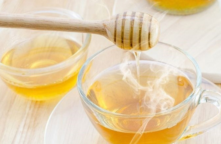 Uống nước ấm pha mật ong giúp bà con giảm nhẹ cơn đau