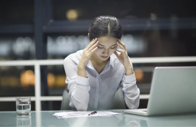 Làm việc nhiều giờ khiến vùng cơ vai gáy co cứng, dẫn đến đau đầu tăng dần về chiều